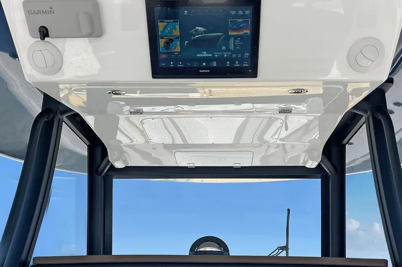 Slide: The Image of 2027 Regulator 35 boat dashboard with Garmin navigation display under clear blue sky. - 13