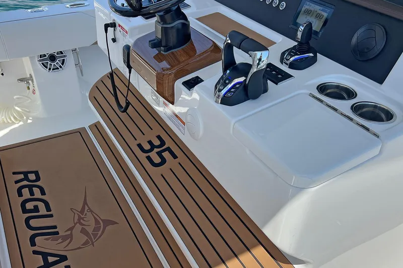 Slide: The Image of Control panel of a 2027 Regulator 35 boat with steering and throttle controls. - 14