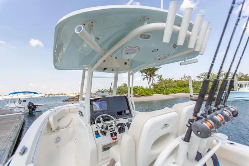 Slide: The Image of Manufacturer Provided Image: 2022 Cobia 262 Center Console boat at a dock, equipped with fishing rods. - 6