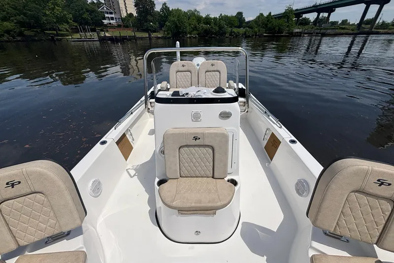 Slide: The Image of 2023 Sea Pro 228 Bay boat interior with beige seating on a calm river. - 10