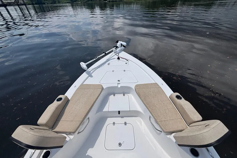 Slide: The Image of 2023 Sea Pro 228 Bay boat with cushioned seating on calm water. - 11