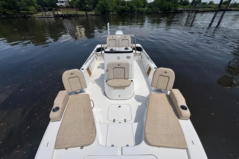 Slide: The Image of 2023 Sea Pro 228 Bay boat with beige seating, docked on a calm river. - 12