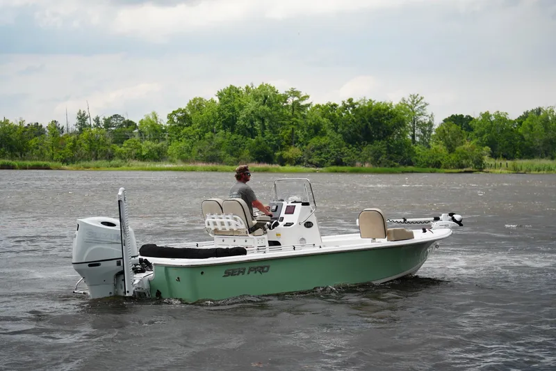 Slide: The Image of 2023 Sea Pro 228 Bay boat cruising on a river with lush green trees. - 3