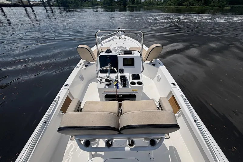 Slide: The Image of 2023 Sea Pro 228 Bay boat interior with steering console on calm water. - 8