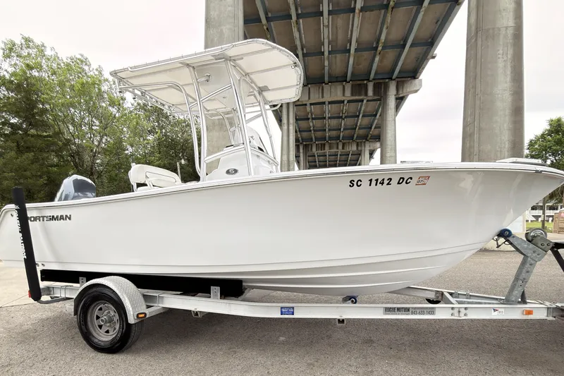 The Image of 2015 Sportsman Open 212 Center Console boat on trailer under bridge. - 0