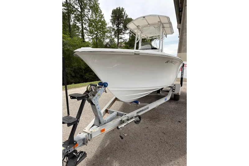 Slide: The Image of 2015 Sportsman Open 212 Center Console boat on trailer, parked outdoors. - 21