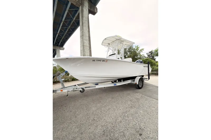 Slide: The Image of 2015 Sportsman Open 212 Center Console boat on trailer under bridge. - 4