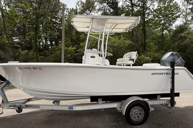 Slide: The Image of 2015 Sportsman Open 212 Center Console boat on trailer, surrounded by trees. - 6