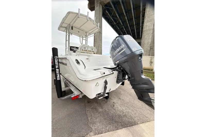 Slide: The Image of 2015 Sportsman Open 212 Center Console boat with Yamaha engine under a bridge. - 7