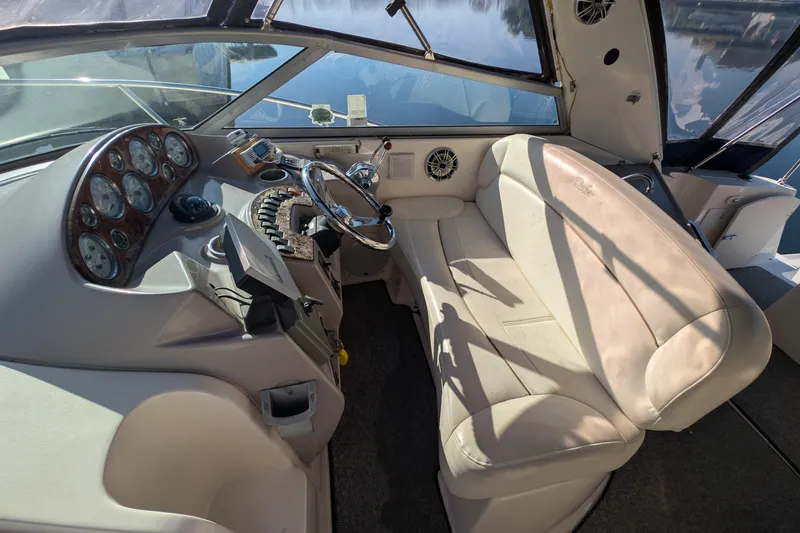Slide: The Image of 2003 Rinker Fiesta Vee 342 boat interior with steering wheel and beige seating. - 17
