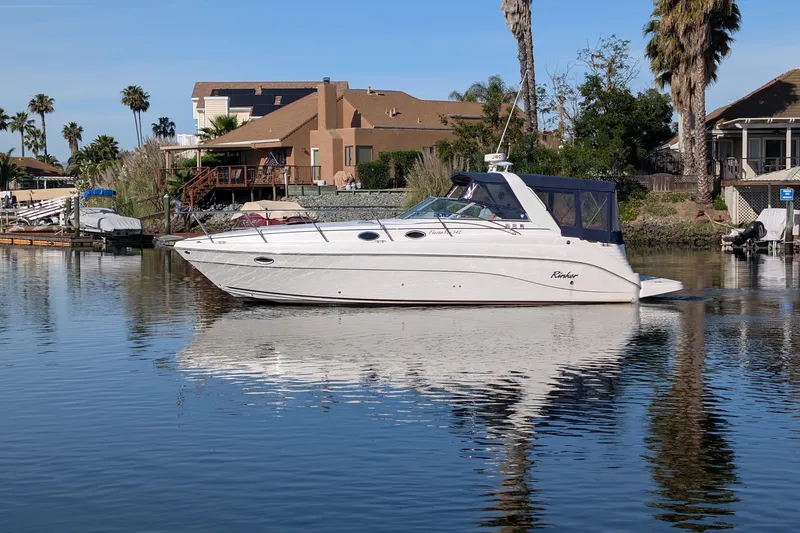 Slide: The Image of 2003 Rinker Fiesta Vee 342 boat on calm water near waterfront homes. - 2