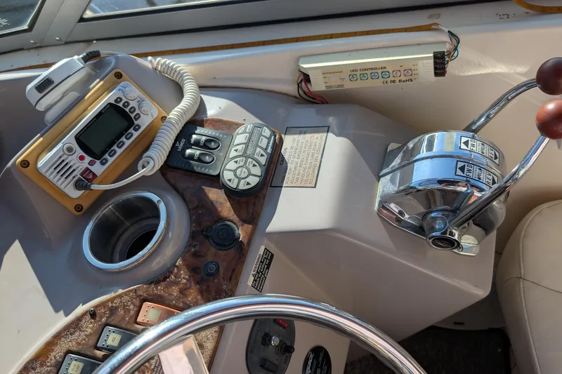 Slide: The Image of 2003 Rinker Fiesta Vee 342 helm with controls, radio, and steering wheel. - 21