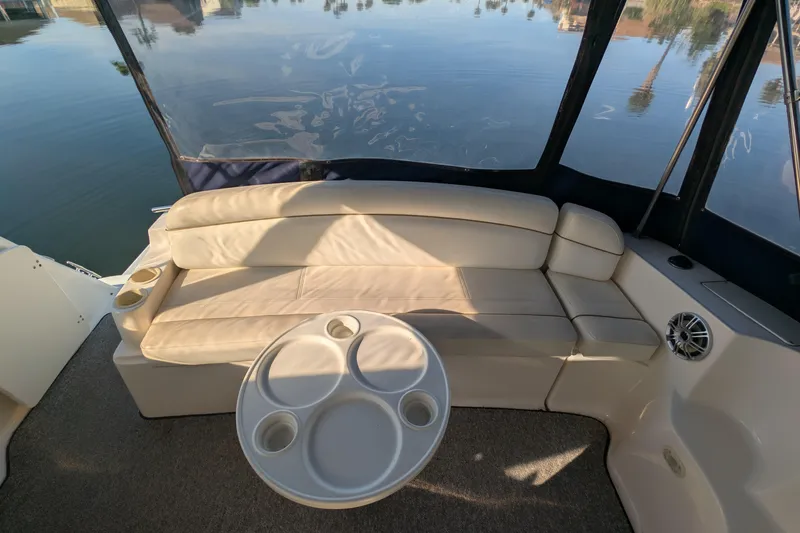 Slide: The Image of 2003 Rinker Fiesta Vee 342 boat interior with beige seating and round table. - 26