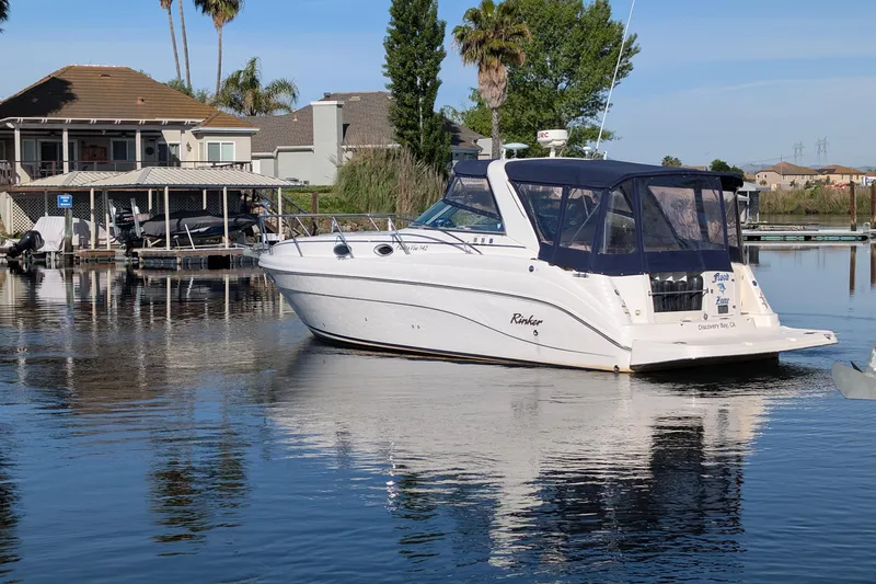 Slide: The Image of 2003 Rinker Fiesta Vee 342 boat docked in a serene waterfront setting. - 3