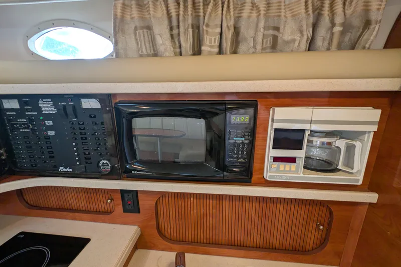 Slide: The Image of 2003 Rinker Fiesta Vee 342 galley with microwave, coffee maker, and control panel. - 34