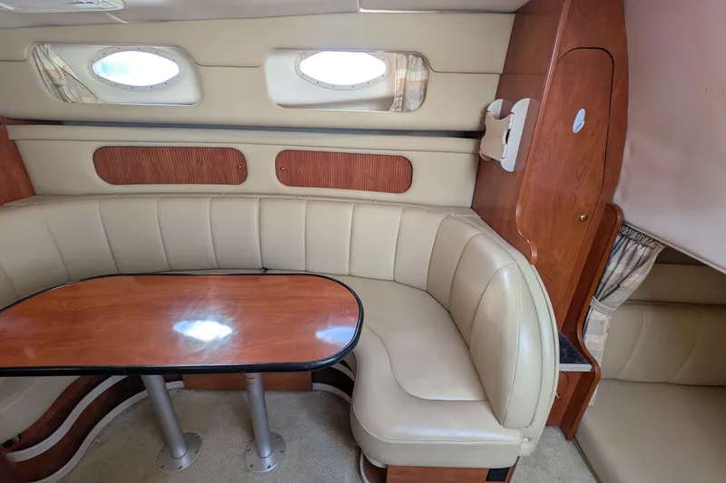 Slide: The Image of Interior of 2003 Rinker Fiesta Vee 342 with beige seating and wooden table. - 39