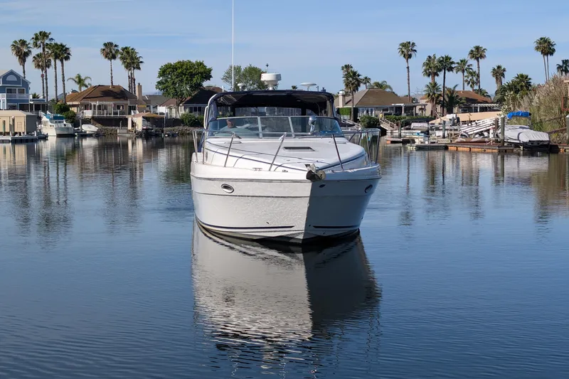 Slide: The Image of 2003 Rinker Fiesta Vee 342 yacht docked in a serene marina with palm trees. - 4