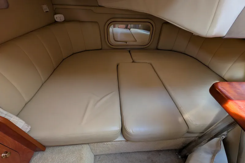 Slide: The Image of Interior cabin of 2003 Rinker Fiesta Vee 342 with beige seating and wooden accents. - 42