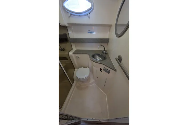 Slide: The Image of 2003 Rinker Fiesta Vee 342 boat bathroom with sink, toilet, and porthole window. - 45