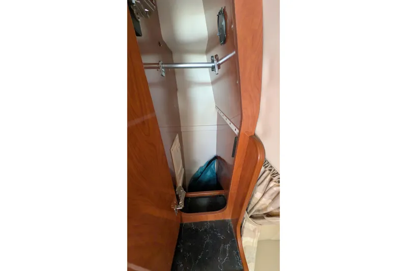 Slide: The Image of 2003 Rinker Fiesta Vee 342 interior closet with wooden finish and hanging rod. - 47