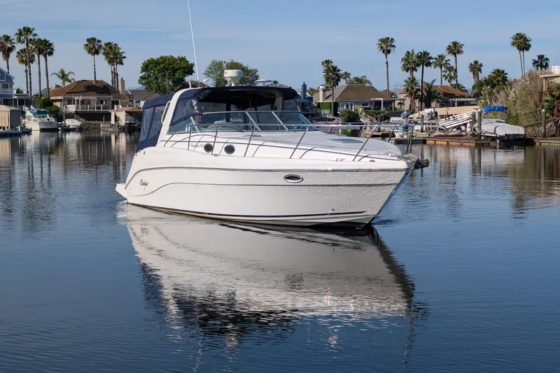 Slide: The Image of 2003 Rinker Fiesta Vee 342 boat on calm water with palm trees in the background. - 5