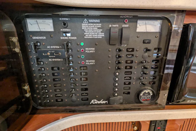 Slide: The Image of Control panel of a 2003 Rinker Fiesta Vee 342 boat, featuring generator and shore power switches. - 52
