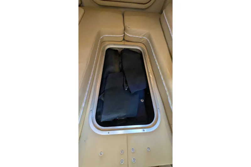 Slide: The Image of Storage compartment in 2003 Rinker Fiesta Vee 342 boat, featuring beige interior seating. - 54