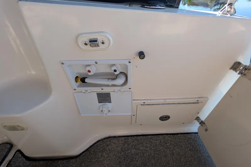 Slide: The Image of 2003 Rinker Fiesta Vee 342 boat interior with utility panel and storage compartment. - 58