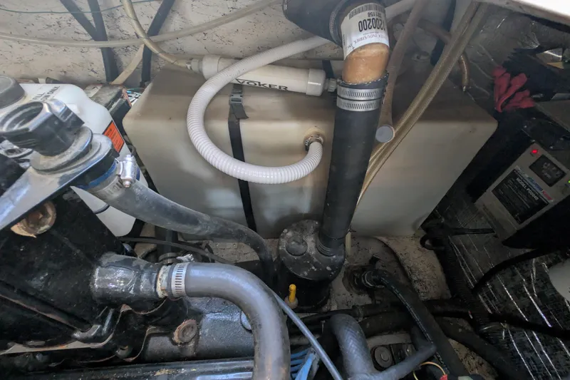 Slide: The Image of Engine compartment of a 2003 Rinker Fiesta Vee 342 with visible hoses and components. - 62