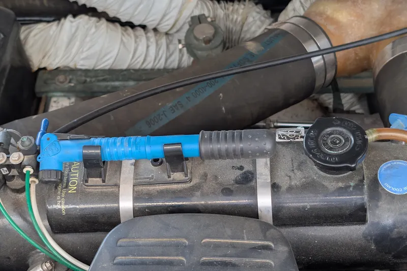 Slide: The Image of Engine compartment of a 2003 Rinker Fiesta Vee 342 boat, featuring hoses and components. - 64