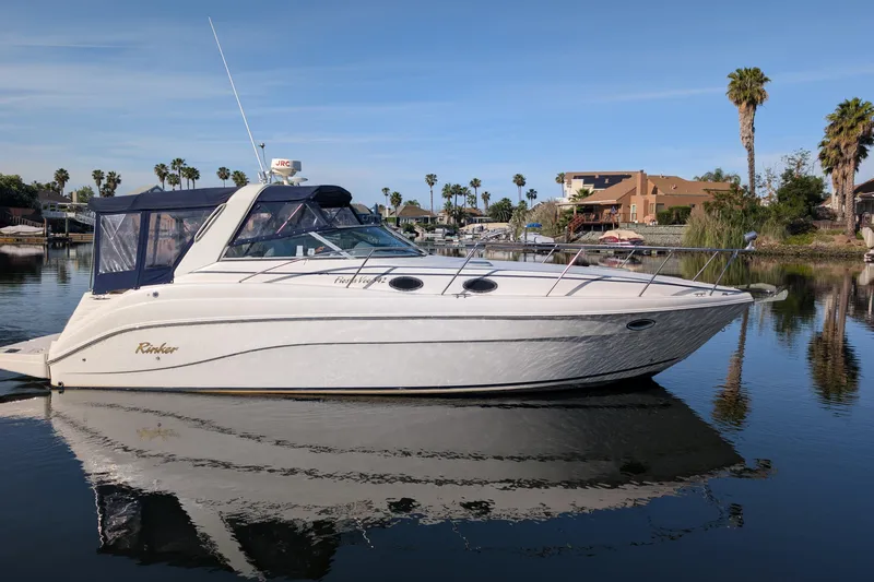 Slide: The Image of 2003 Rinker Fiesta Vee 342 boat docked on calm water with palm trees in background. - 7