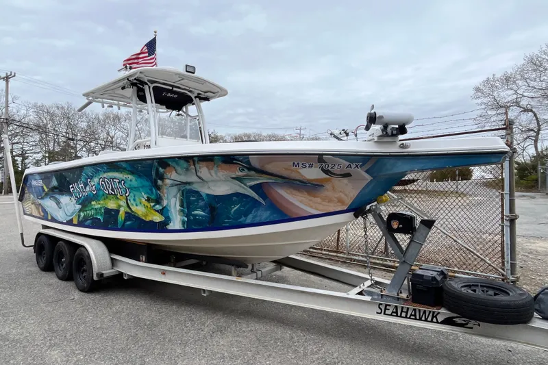 The Image of 2005 Angler 2700CC boat with vibrant marine artwork on a trailer. - 1