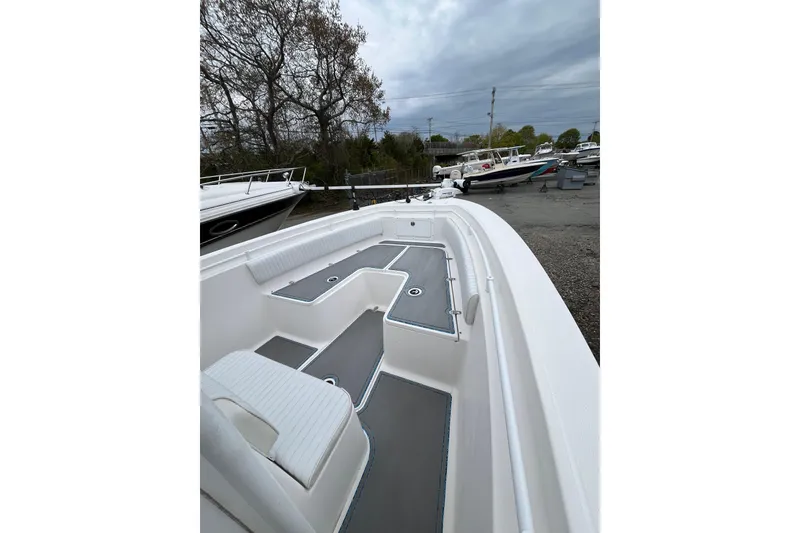 Slide: The Image of 2005 Angler 2700CC boat with spacious deck, white seating, and gray flooring. - 11