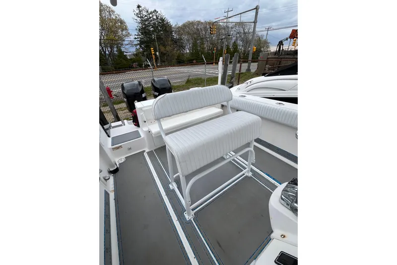 Slide: The Image of 2005 Angler 2700CC boat interior with white seating and dual Mercury engines. - 17