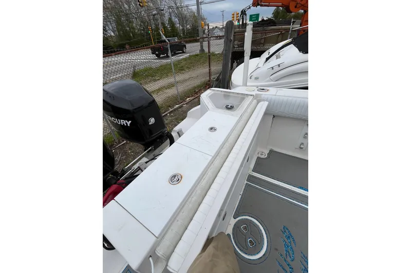 Slide: The Image of 2005 Angler 2700CC boat with Mercury outboard motor, parked near a road. - 19