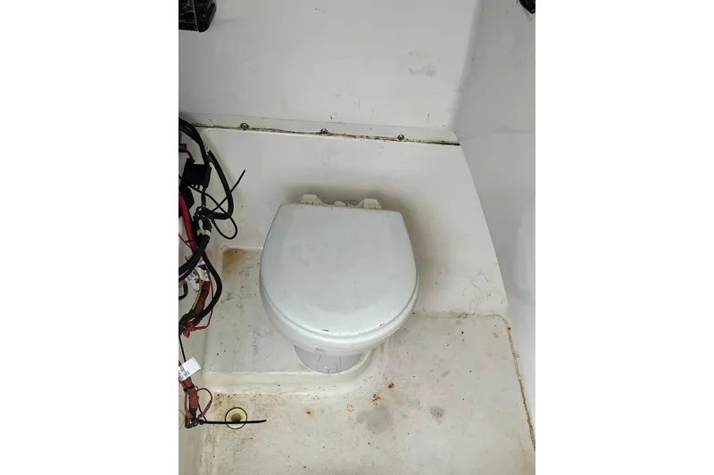 Slide: The Image of 2005 Angler 2700CC boat interior with marine toilet and wiring. - 25