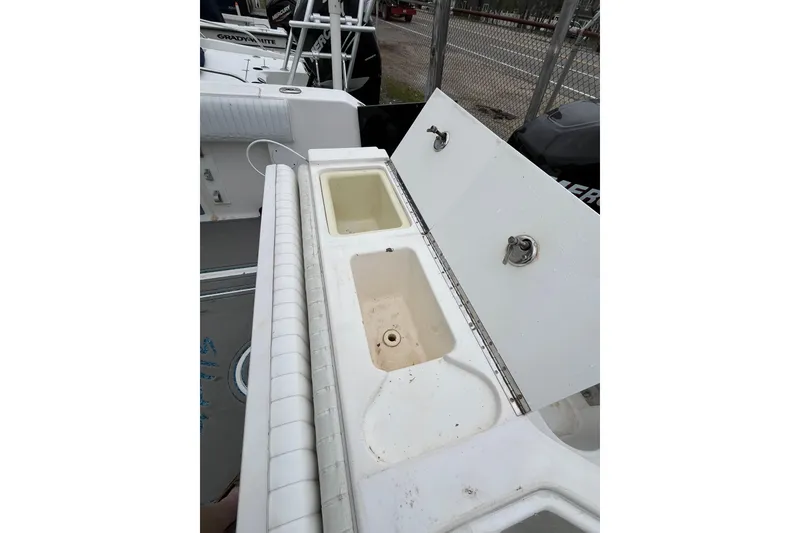Slide: The Image of 2005 Angler 2700CC boat with open storage compartments and seating area. - 27