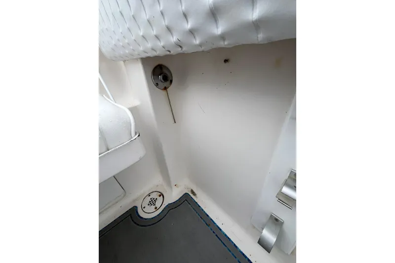 Slide: The Image of Interior view of a 2005 Angler 2700CC boat, featuring a drain and seating area. - 30