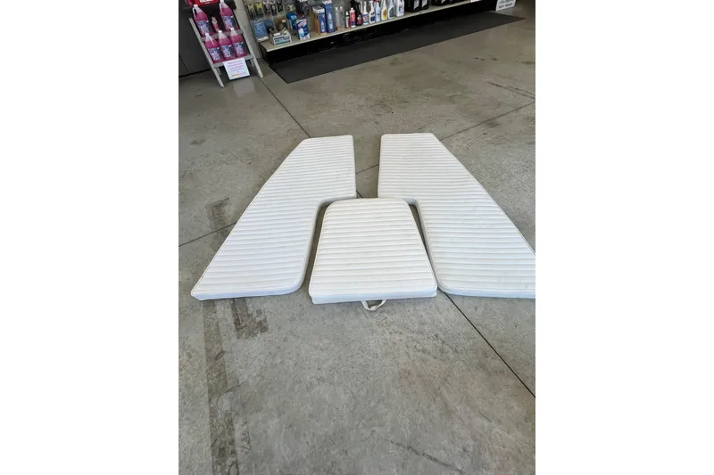 Slide: The Image of White boat cushions for 2005 Angler 2700CC displayed on a concrete floor. - 36