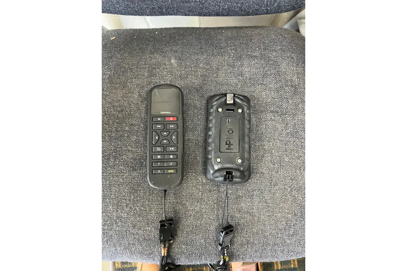 Slide: The Image of Remote controls on a gray fabric surface, related to a 2005 Angler 2700CC boat. - 39