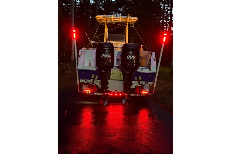 Slide: The Image of 2005 Angler 2700CC boat with dual 200HP engines, illuminated at night. - 6