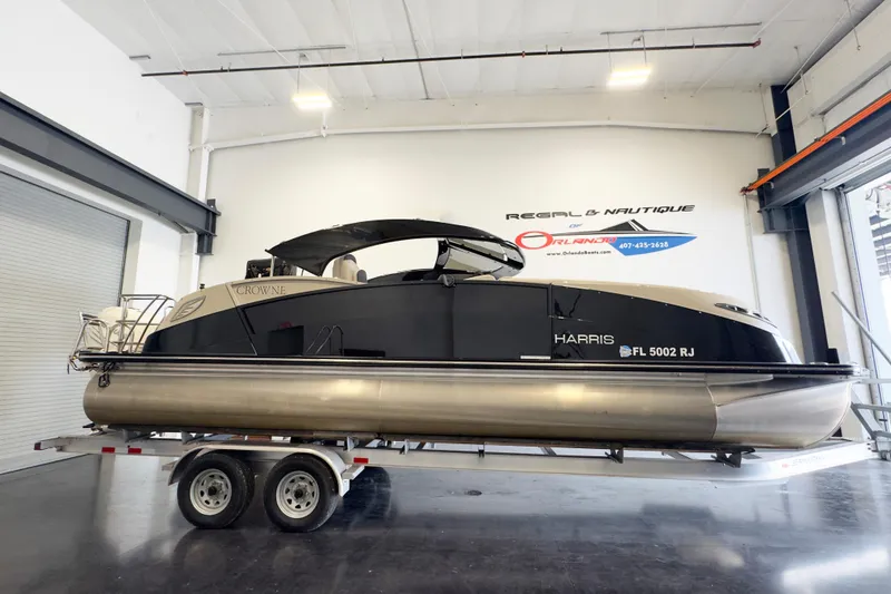 The Image of 2017 Harris Crowne 250 pontoon boat on trailer in indoor showroom. - 1