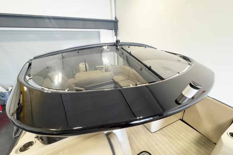 Slide: The Image of 2017 Harris Crowne 250 boat interior with sleek black canopy and beige seating. - 15
