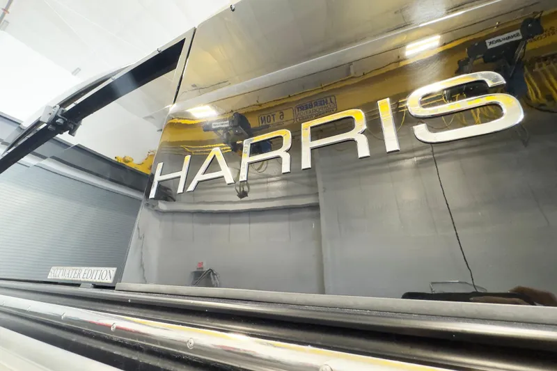 Slide: The Image of 2017 Harris Crowne 250 boat with sleek metallic branding in a showroom. - 17