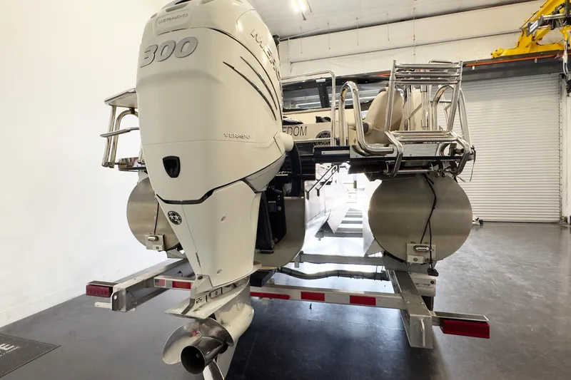 Slide: The Image of 2017 Harris Crowne 250 pontoon boat with powerful 300 Verado engine in a garage setting. - 5