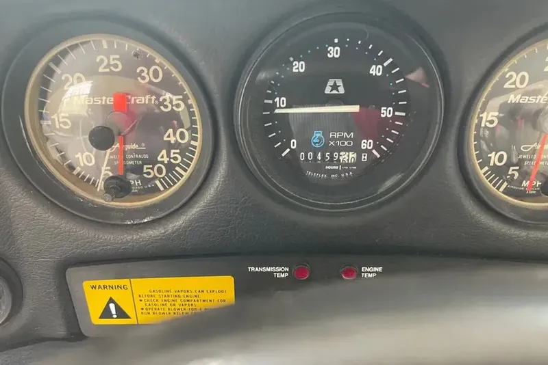 Slide: The Image of Dashboard of a 1994 MasterCraft 205 Prostar with gauges and warning labels. - 2