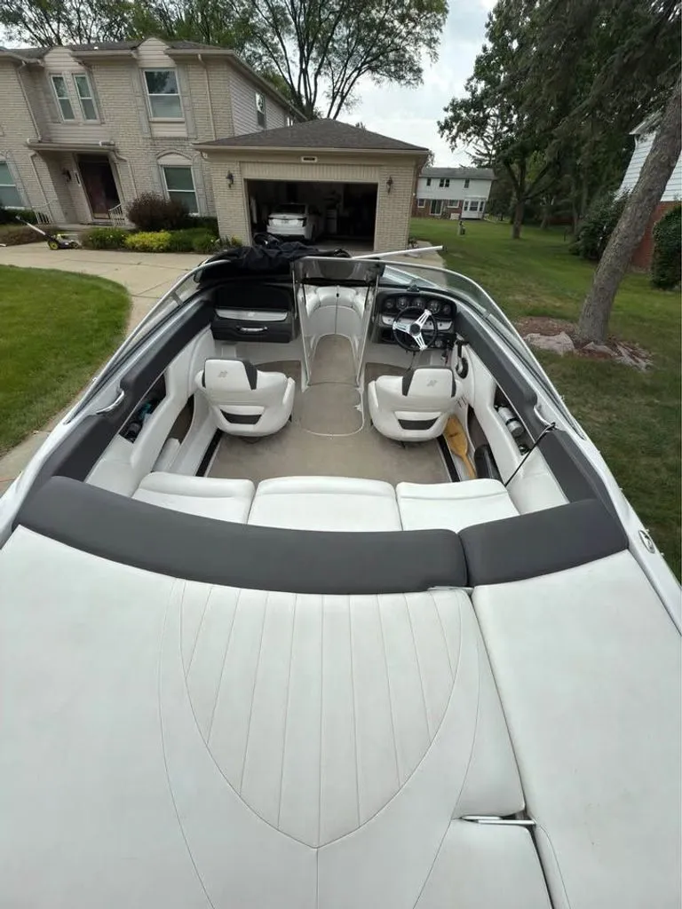 Slide: The Image of Interior of a 2010 Four Winns H210 boat parked at a house. - 2