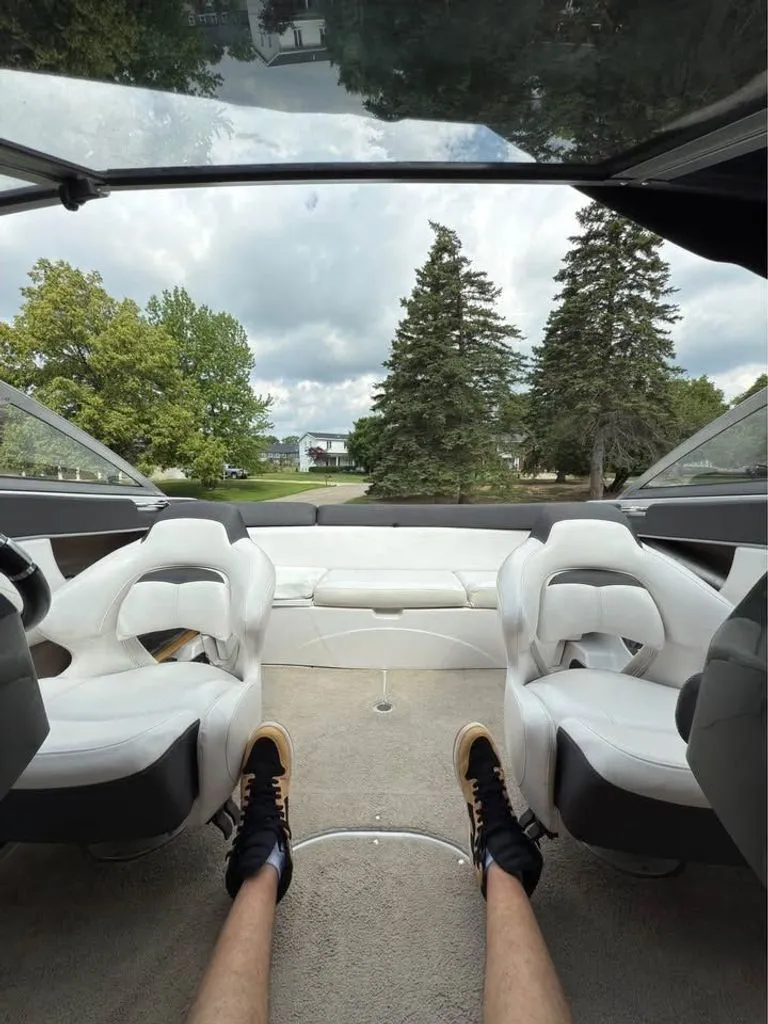 Slide: The Image of Interior view of a 2010 Four Winns H210 boat with white seats. - 6