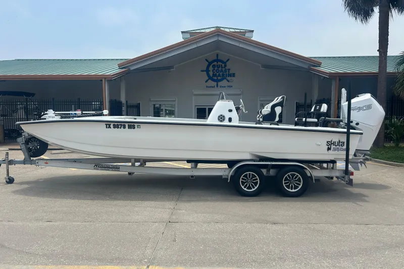 The Image of 2025 Skuta 24 boat on trailer outside Gulf Coast Marine building. - 0