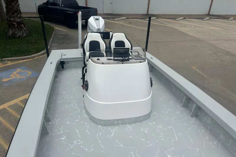 Slide: The Image of 2025 Skuta 24 boat with dual seats and sleek design in a parking area. - 13